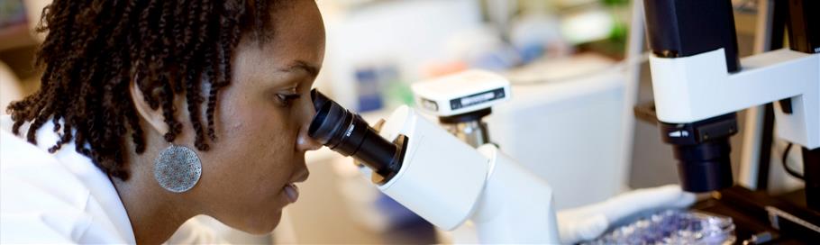 At the microscope Woman looking into microscope